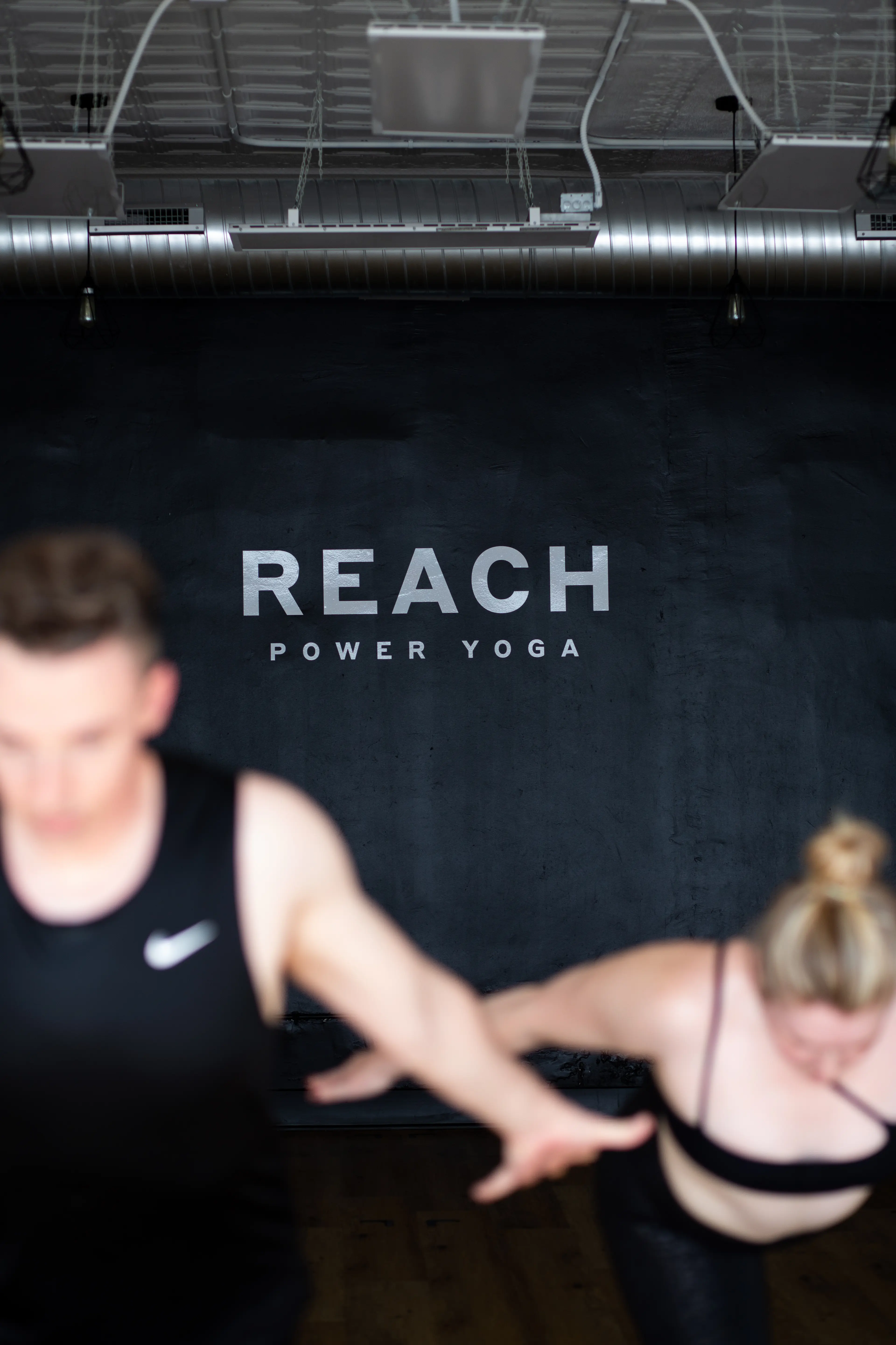 Reach Power Yoga studio interior with logo wall and instructors