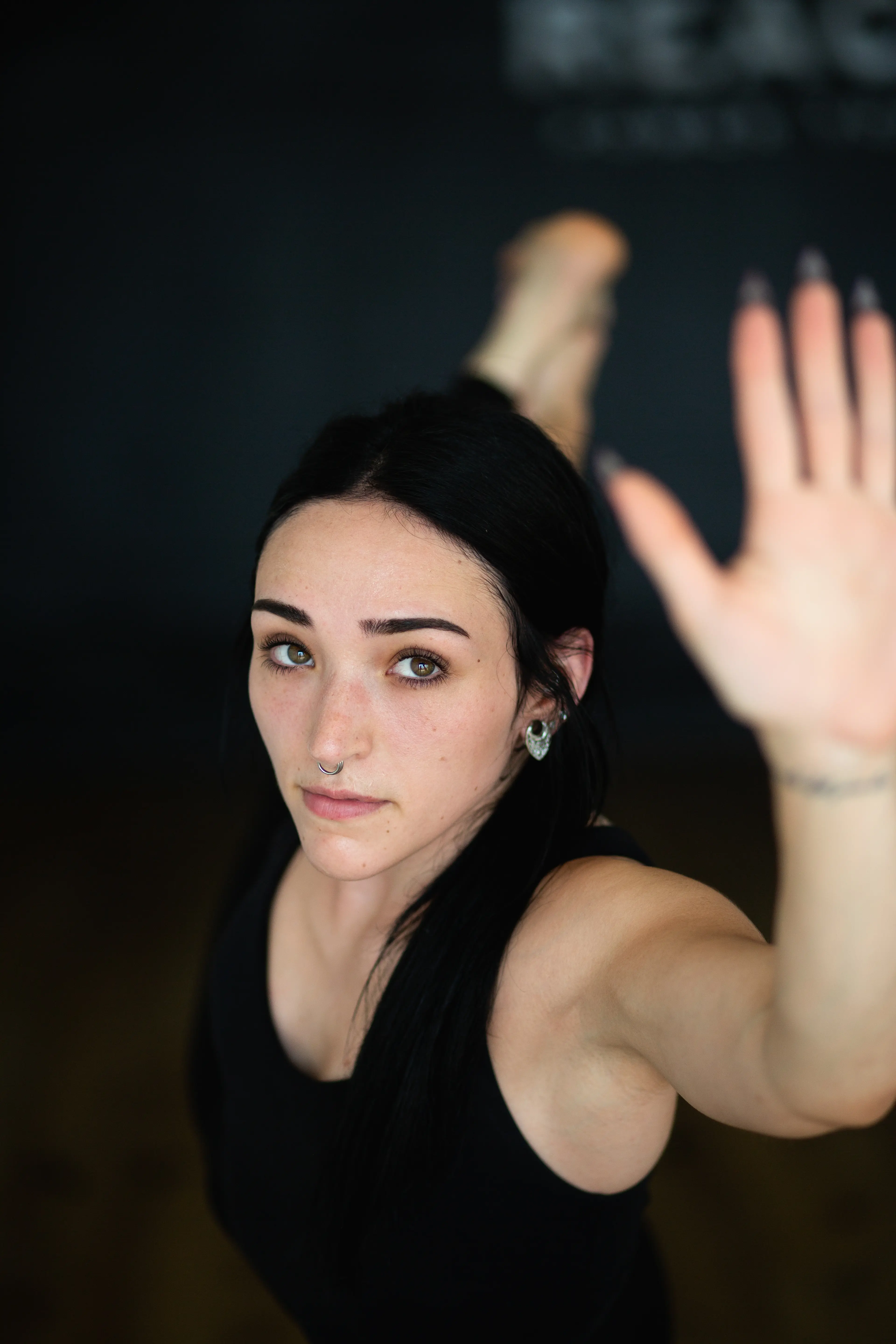 Close-up portrait of a yoga student with hand raised at Reach Power Yoga