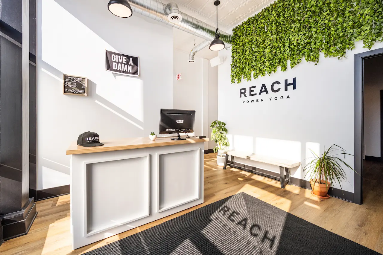 Reach Power Yoga studio reception desk with green plant wall